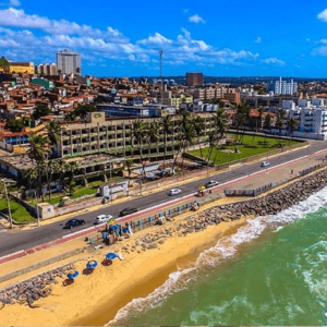 Imagem da praia do meio, com várias casas ao fundo e um grande prédio no meio.